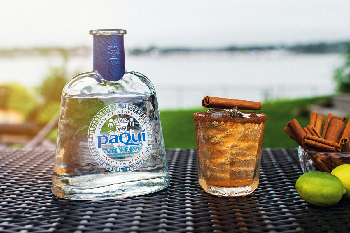 PaQui Silvera Tequila bottle with cinnamon cocktail and waterfront view